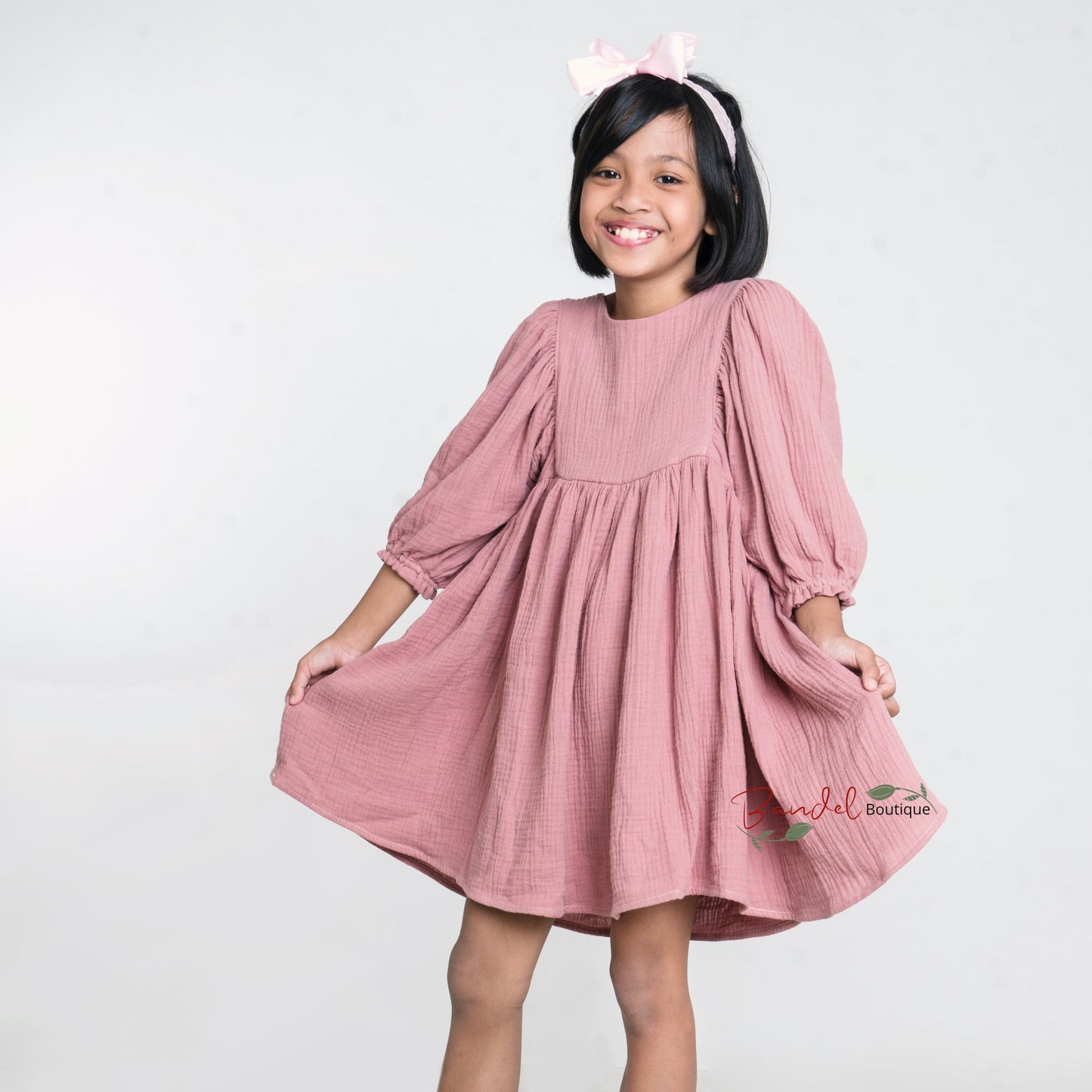 handmade muslin girl dress with 3/4 length ruffled sleeves. Crafted with care and attention to detail, this knee- length Double Gauze Girl dress exudes charm and sophistication. The ruffled hem with elastic casing adds a playful touch, while the comfortable muslin fabric ensures all-day comfort for your child.