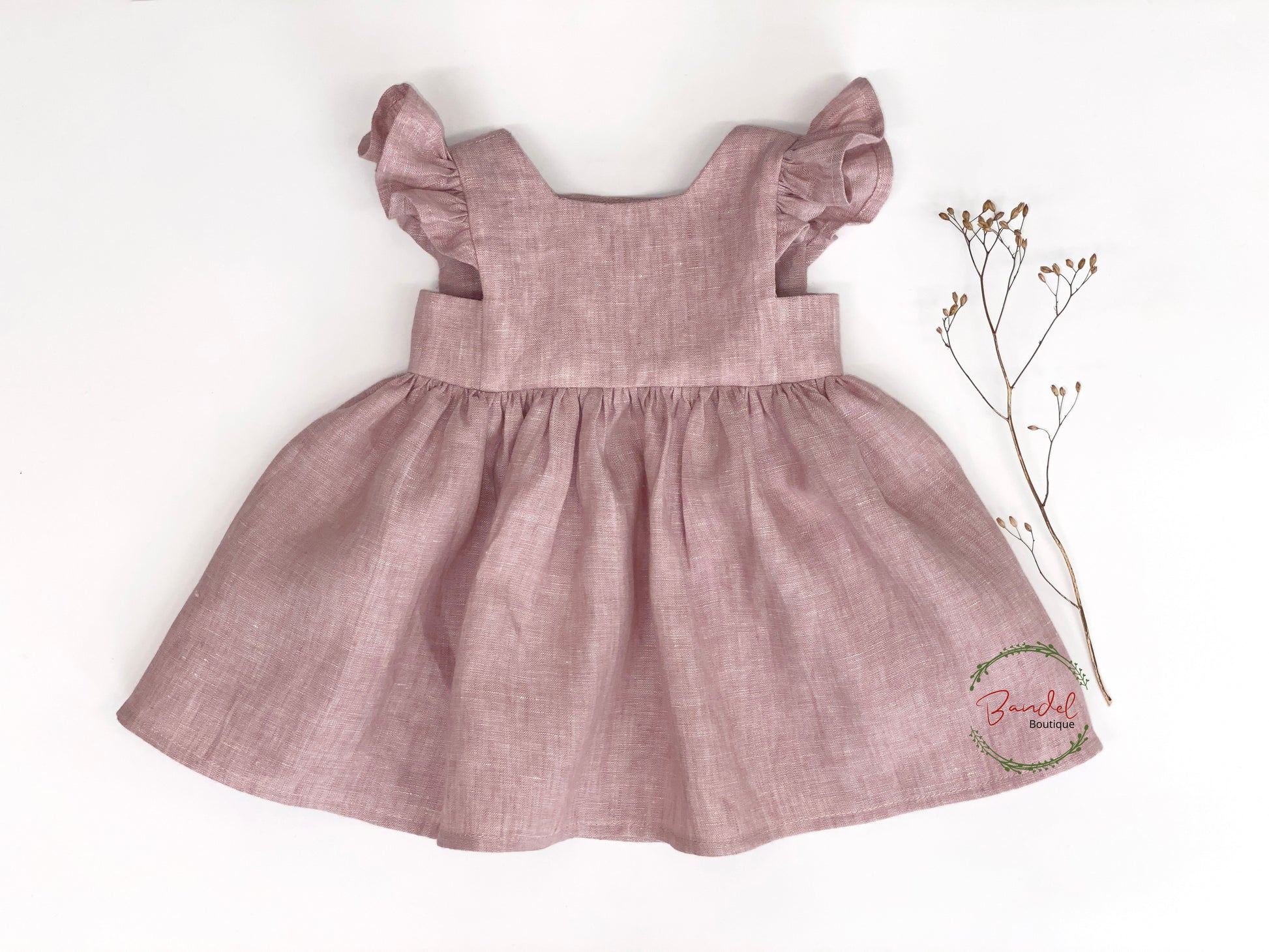 This linen girl dress is perfect for any occasion. It is crafted from high-quality, lightweight linen in an elegant old pink color. The bodice features a square neckline, flutter sleeves, and a skirt hem ruffle that is accentuated by a double row of wooden buttons in the back. This timeless piece is sure to become your child's favorite.