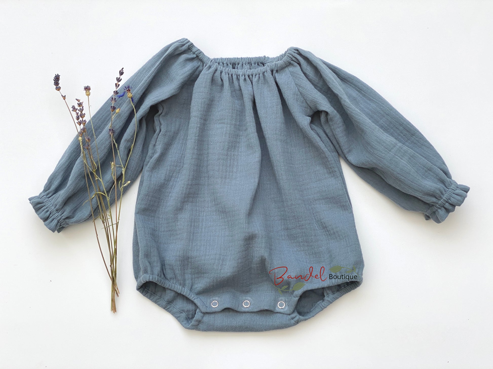 Handmade dusty- blue minimalist newborn baby romper with long sleeves, made from breathable and soft double gauze organic fabric. Features elasticized openings and crotch snaps for easy dressing and maximum comfort. 