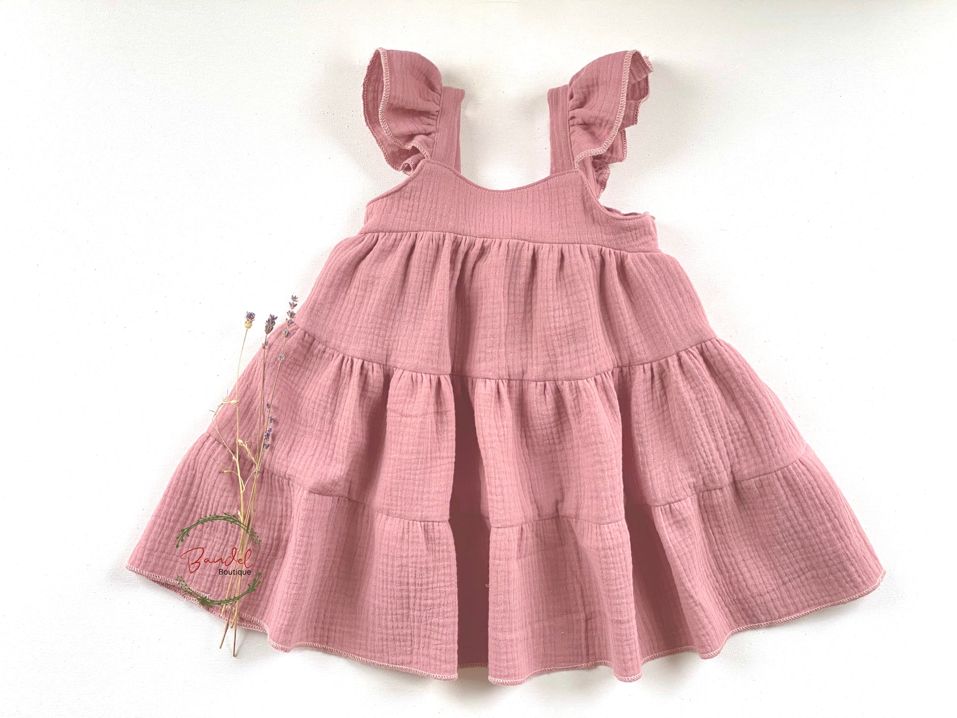 Old-Pink Muslin Flutters Sleeve Dress adds a timeless touch of style to your little one's wardrobe. Made of double gauze fabric for a comfortable fit and featuring an elastic back bodice and gathered tiered skirt, this dress is perfect for every occasion. Flutter sleeves and a classic color give this dress a unique, tasteful look.