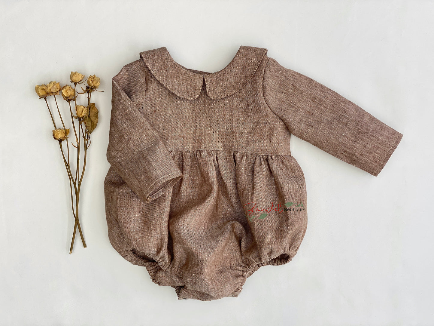 Classic Linen Playsuit in Brown is made of medium weight linen, perfectly combining comfort and style for your baby. It features a Peter Pan collar, long sleeves, and elastic at the legs to ensure a snug fit. Wooden buttons and snaps at the back and crotch make changing your little one effortless.