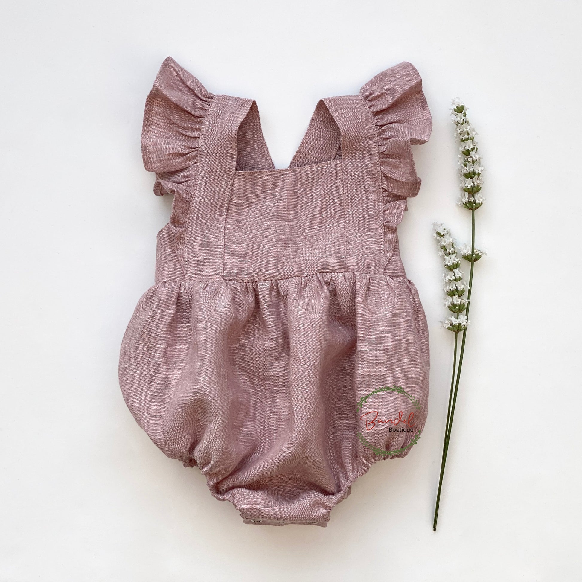 old- rose vintage-inspired Linen Bubble Romper is handmade with care in the Netherlands, making it a unique piece for your baby's wardrobe. This playsuit features sleeve ruffles, elastic at the leg for a comfortable fit, adjustable button straps with two buttonholes, and snaps at the crotch for easy diaper changes.