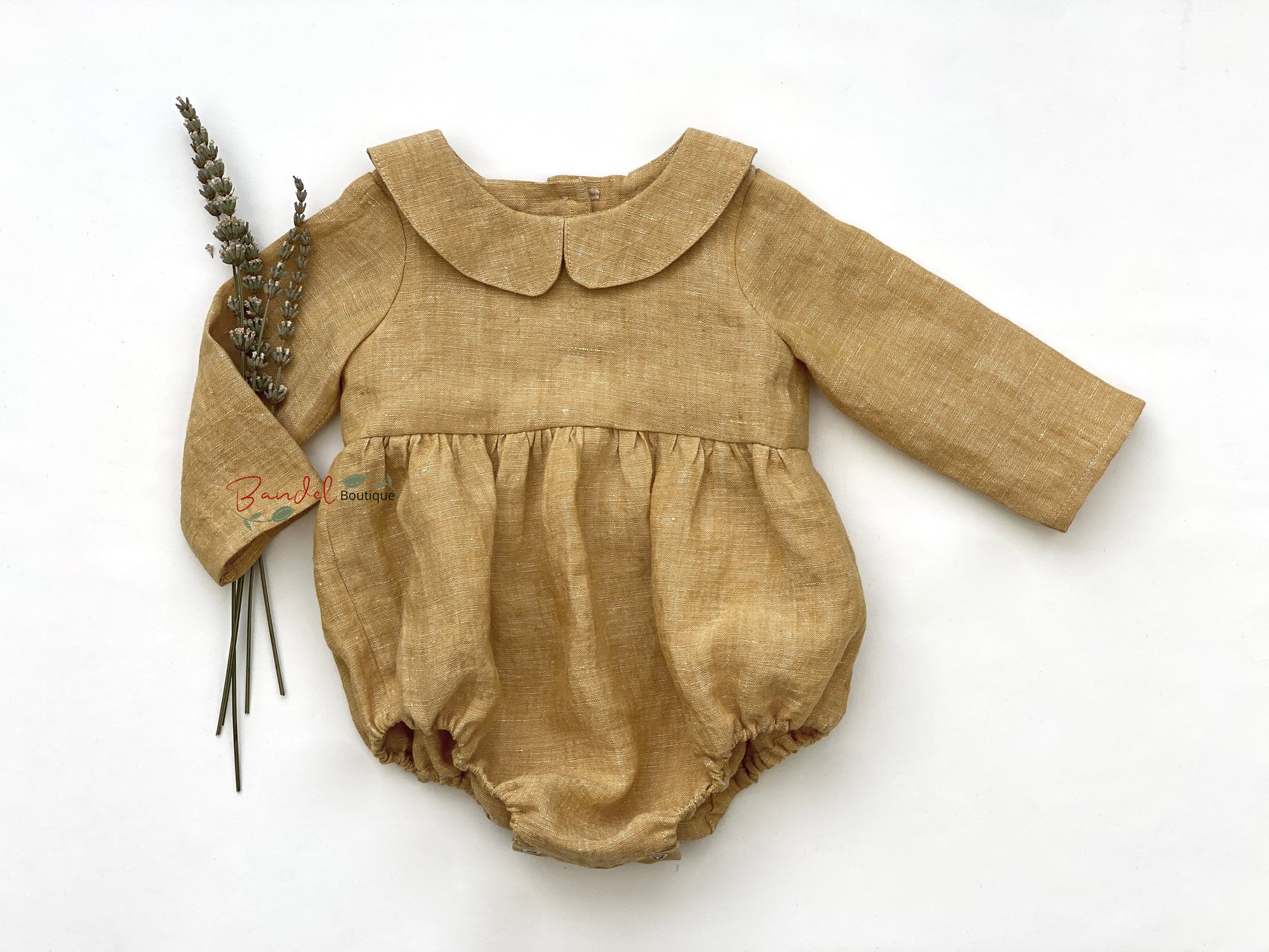 This stylish ocher yellow linen romper is perfect for your baby's wardrobe. Crafted from durable and soft linen, this romper features long sleeves, a peter pan collar, and snaps at the crotch for easy changes. Its classic design will ensure your baby looks stylish while feeling comfortable.