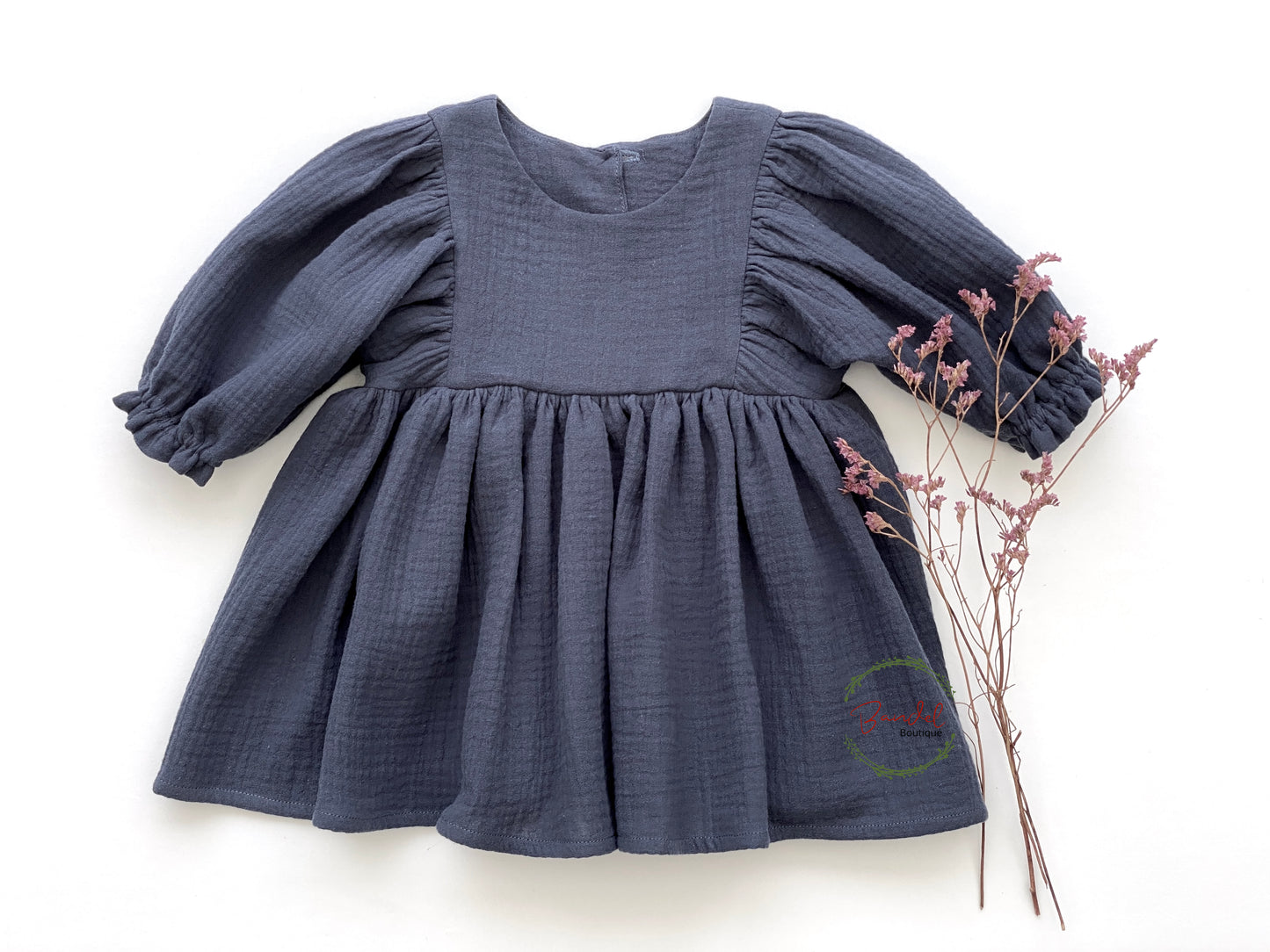 This beautiful Denim Blue 3/4 Sleeves Muslin Dress is perfect for your little girl. Crafted from organic muslin, the dress features elasticated sleeves with a frilly hem and wooden button closure on the back bodice. With a knee-length design, you can be sure to find the perfect look for any occasion.