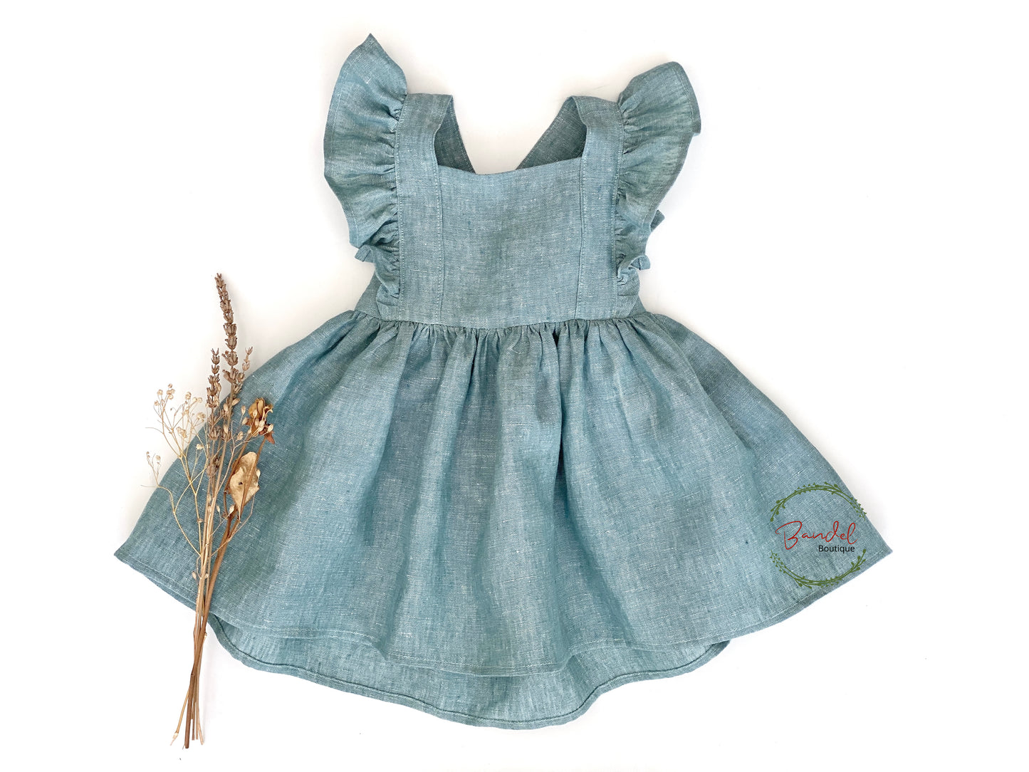 Dusty Mint Vintage Dress will bring an elegant touch to any girl's wardrobe. Crafted from delicate linen, the pinafore dress features exquisite ruffled sleeves, adjustable straps, and a gathered skirt for an effortlessly sophisticated look. Perfect for those who appreciate classic sophistication.