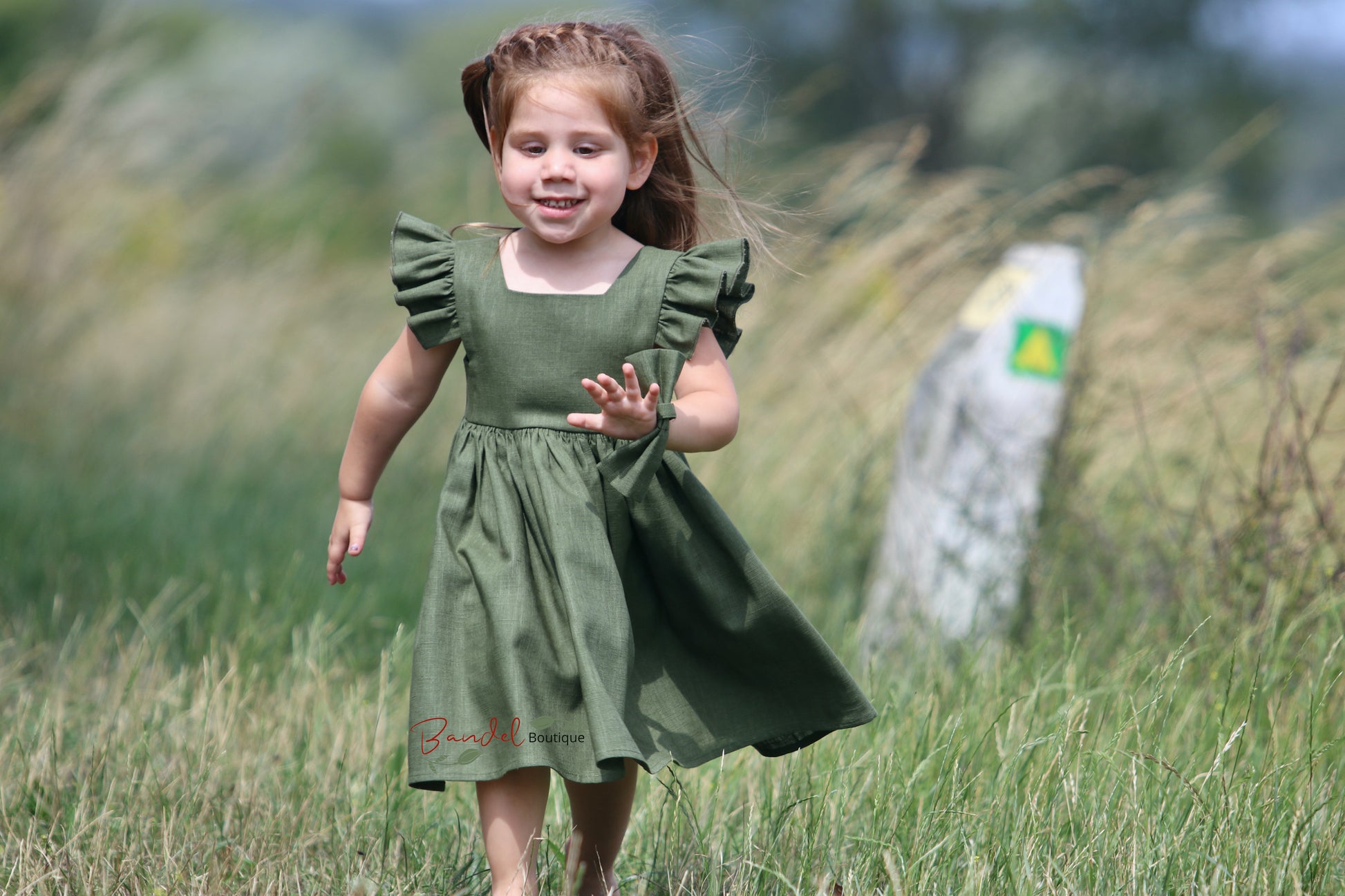 Green Girl Linen Dress will add a touch of whimsy to your special occasion. Boasting a vintage style, the avocado-green dress showcases a square neckline, flutter sleeves and a playful ruffle hem. The back features a double row of rustic wooden buttons, adding a boho touch to your wedding.