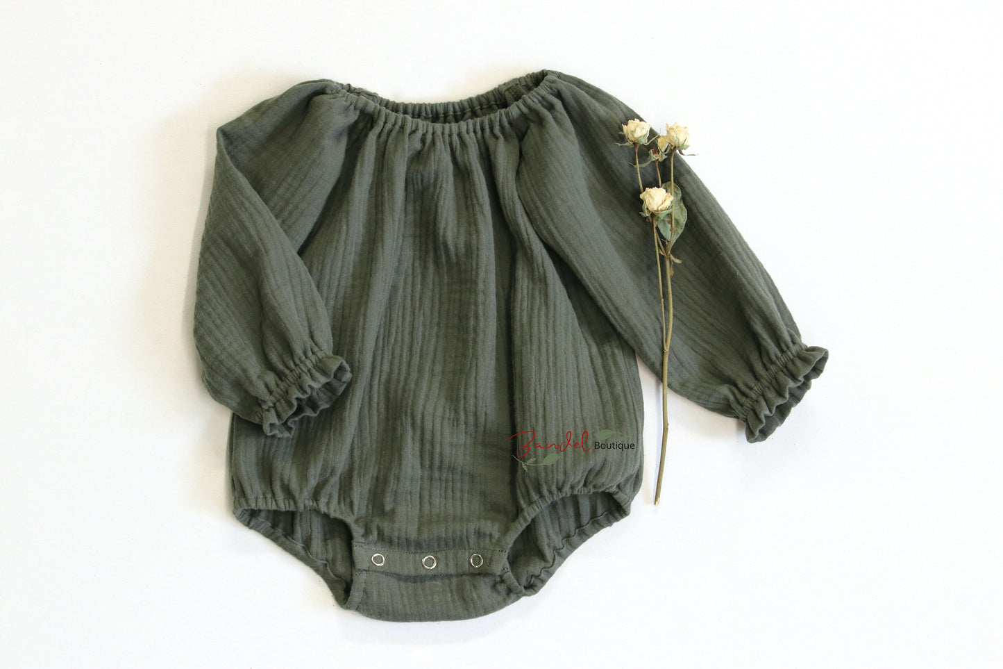 Handmade olive green minimalist newborn baby romper with long sleeves, made from breathable and soft double gauze organic fabric. Features elasticized openings and crotch snaps for easy dressing and maximum comfort. 