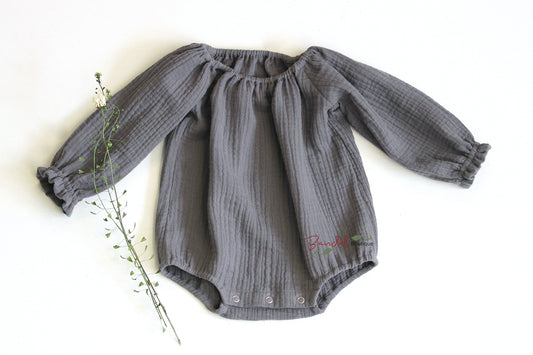 Handmade grey minimalist newborn baby romper with long sleeves, made from breathable and soft double gauze organic fabric. Features elasticized openings and crotch snaps for easy dressing and maximum comfort. 