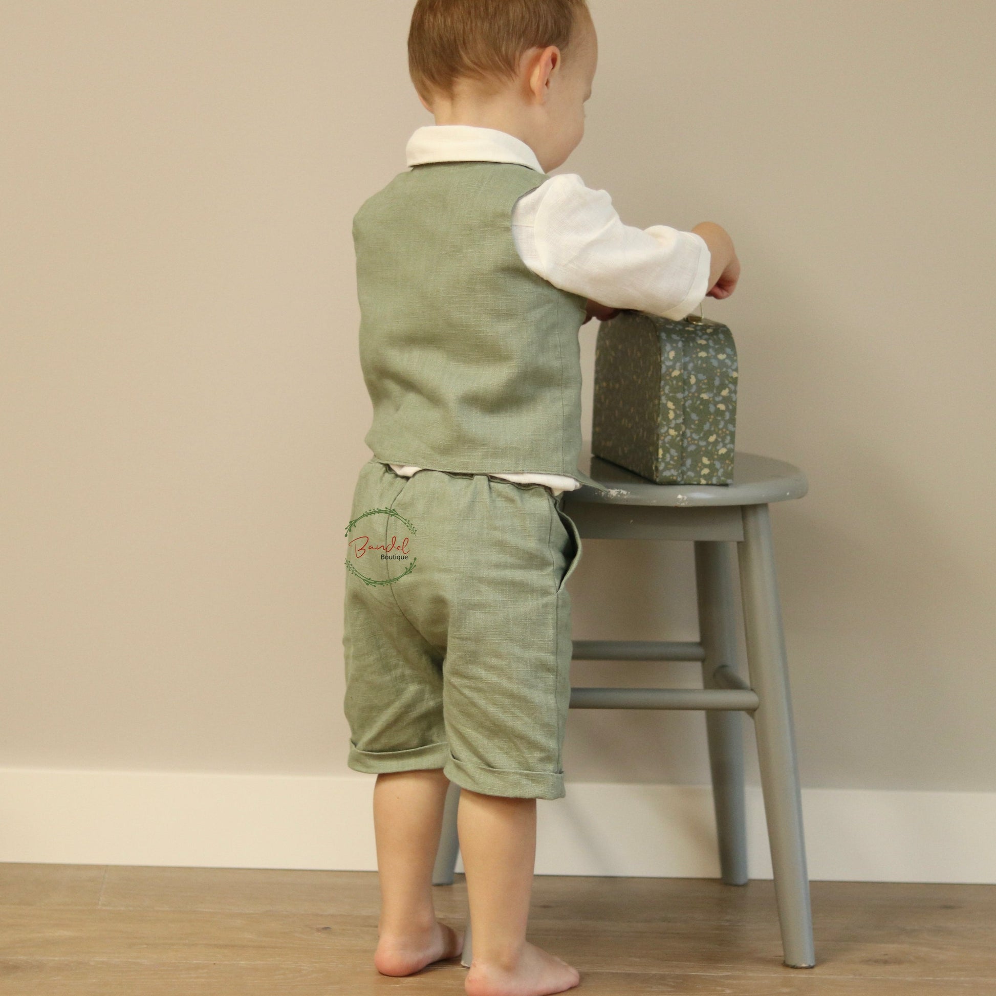 This Dark-Mint Pageboy outfit features a short and vest tailored with elasticized back waistband and front wooden buttons, and an ivory shirt with a collar and 3/4-length sleeves. Its classic design ensures a comfortable fit with two side pockets for maximum convenience.