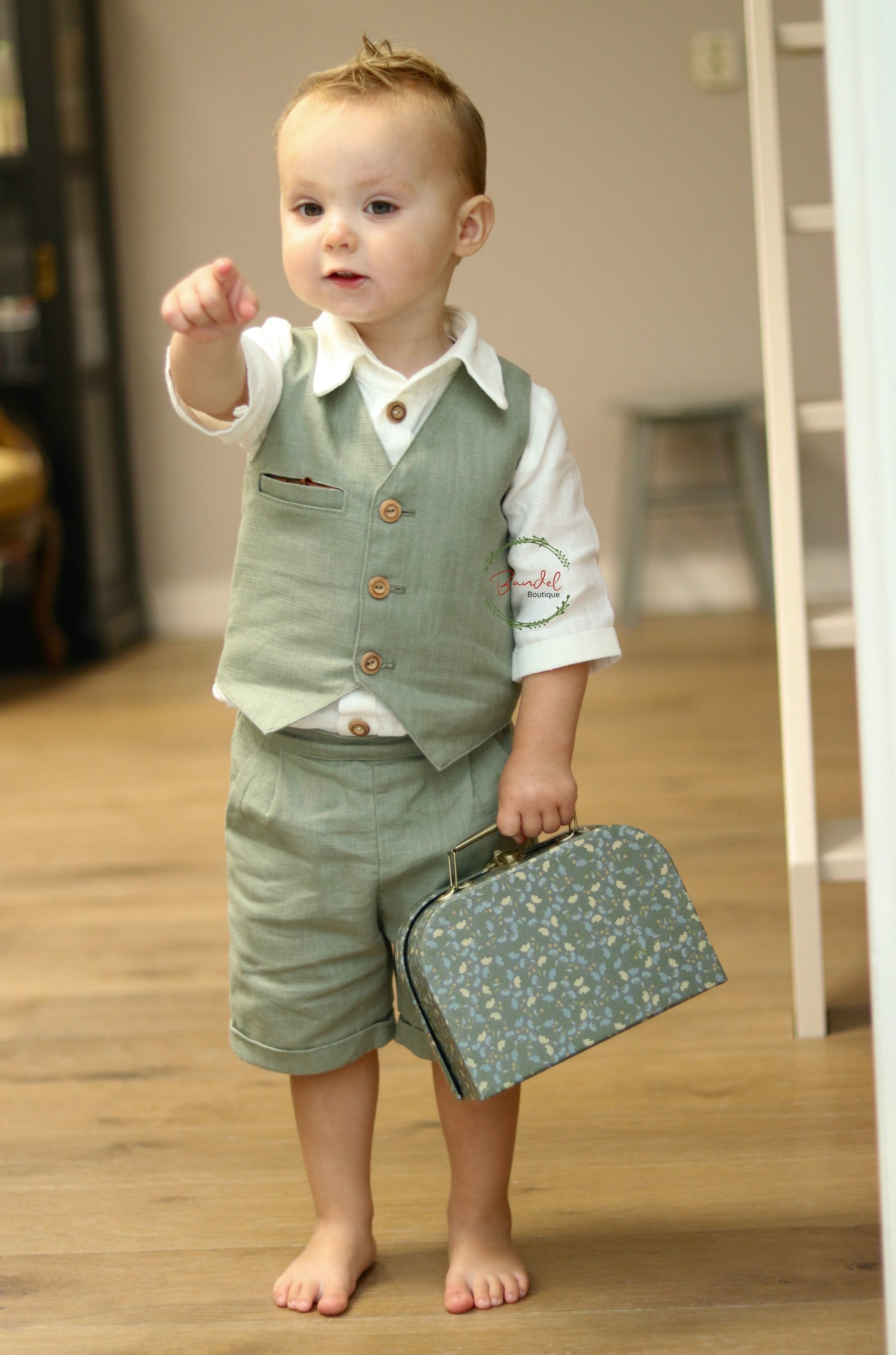 This Dark-Mint Pageboy outfit features a short and vest tailored with elasticized back waistband and front wooden buttons, and an ivory shirt with a collar and 3/4-length sleeves. Its classic design ensures a comfortable fit with two side pockets for maximum convenience.