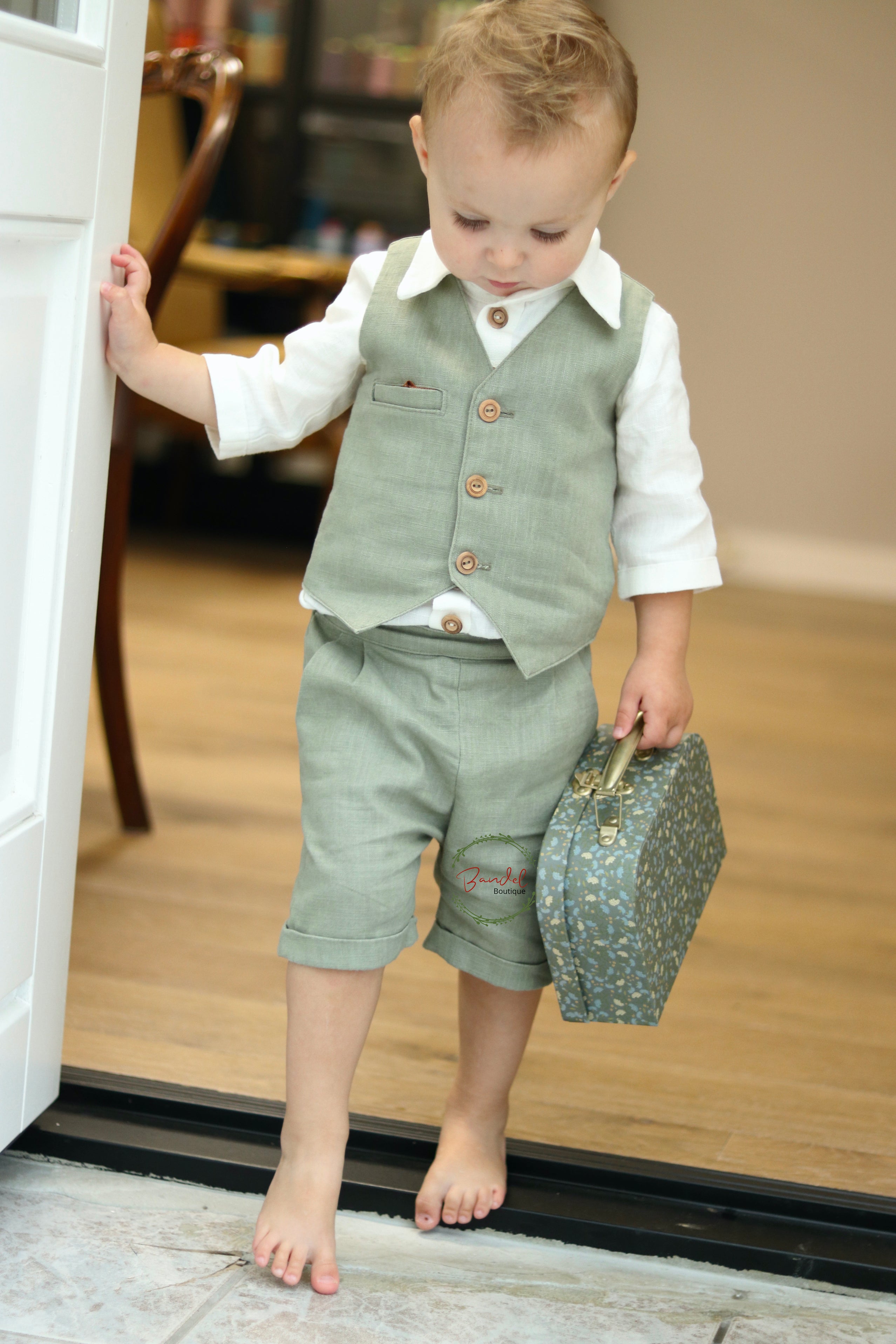 This Dark-Mint Pageboy outfit features a short and vest tailored with elasticized back waistband and front wooden buttons, and an ivory shirt with a collar and 3/4-length sleeves. Its classic design ensures a comfortable fit with two side pockets for maximum convenience.